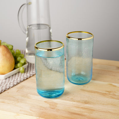 AQUA TINTED GLASS TUMBLERS WITH GOLD RIM - Subtle elegance makes this glassware an excellent addition to any home bar. The lightly tinted blue-green glass recalls the ocean, while the electroplated gold rim adds an upscale accent.
