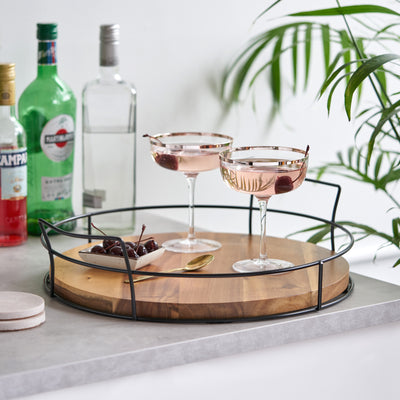 ACACIA WOOD AND METAL SERVING TRAY - Whether you’re hosting happy hour and serving hors d'oeuvres or bringing out glasses of champagne, this gorgeous wooden tray will add a new level of finesse to your presentation. Bring panache to your bar cart.
