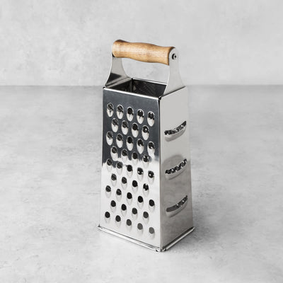 WOOD HANDLED CHEESE GRATER - With a warm, natural acacia wood handle and sturdy stainless steel construction, this classic box grater is useful and beautiful. Upgrade your kitchen tools with this stylish vintage kitchenware.
